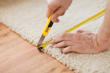 Installer cutting carpet